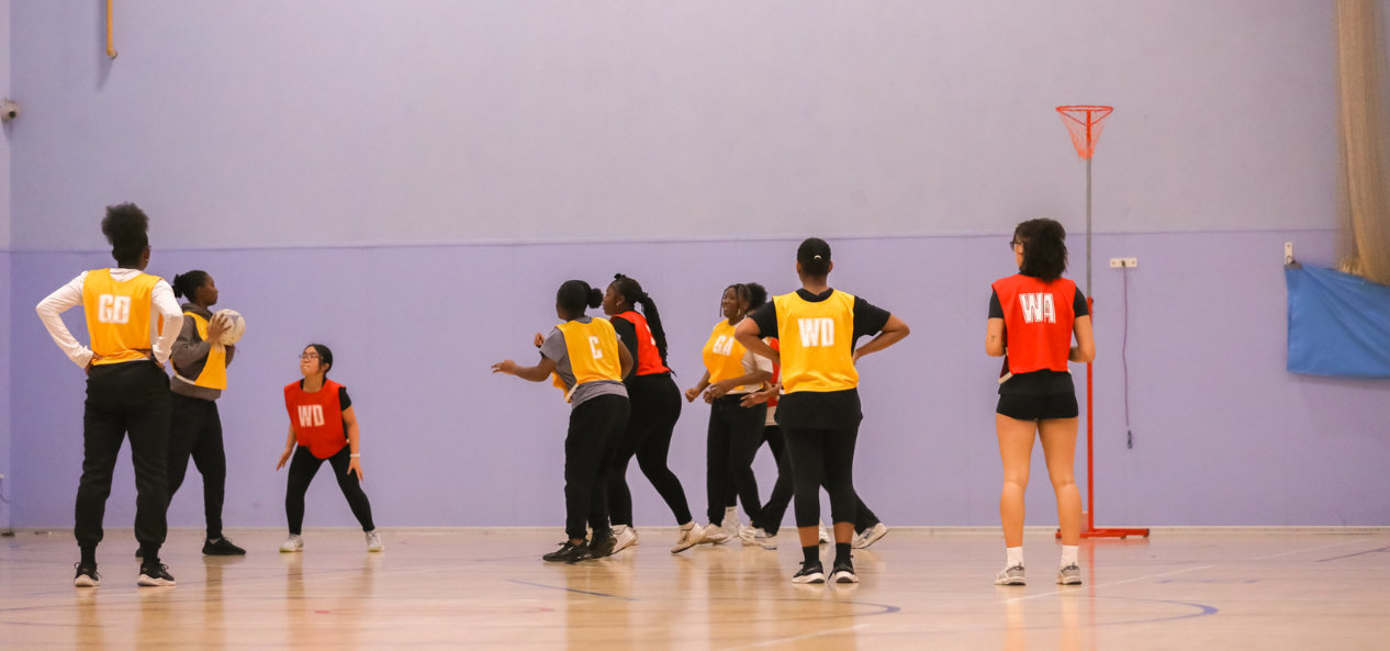 Girls playing netball in indoor court