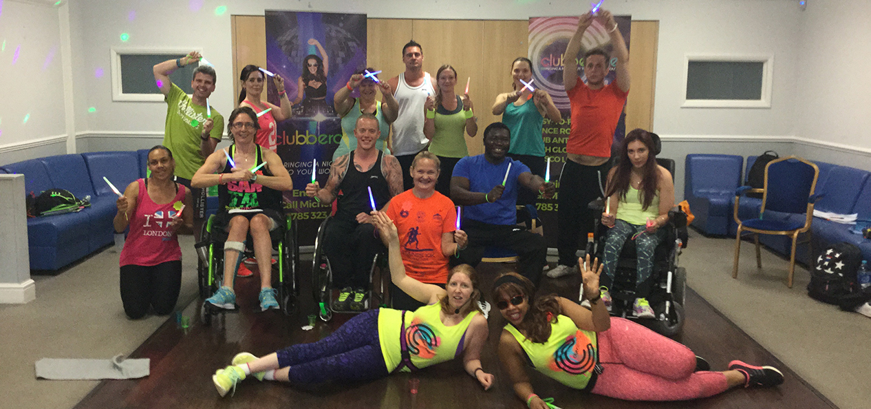 Group photo of disabled fitness professionals on a dance fitness certification training day at an indoors gym.