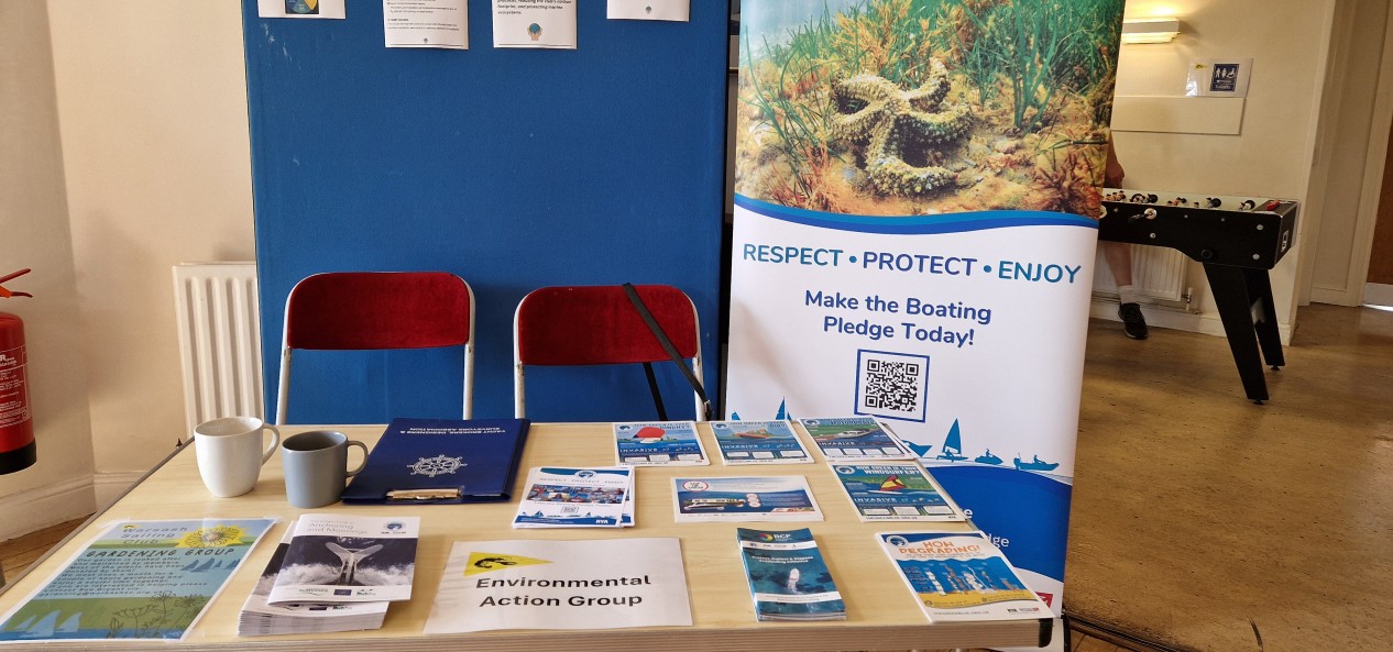 Table and banners at Warsash Sailing Club's open day, featuring leaflets and information on environmental sustainability.
