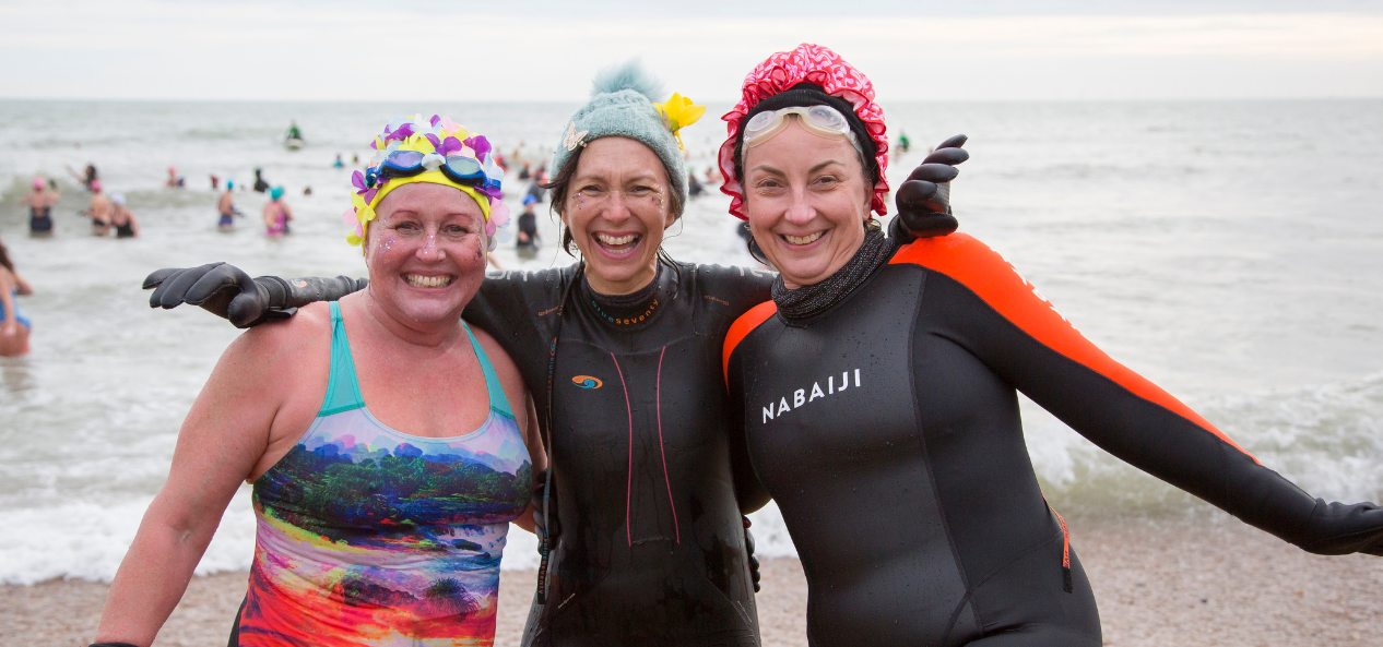 Three women in wetsuits 