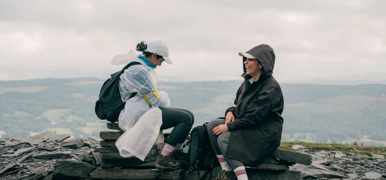 Two women from Muslim Hikers group sit on rocks