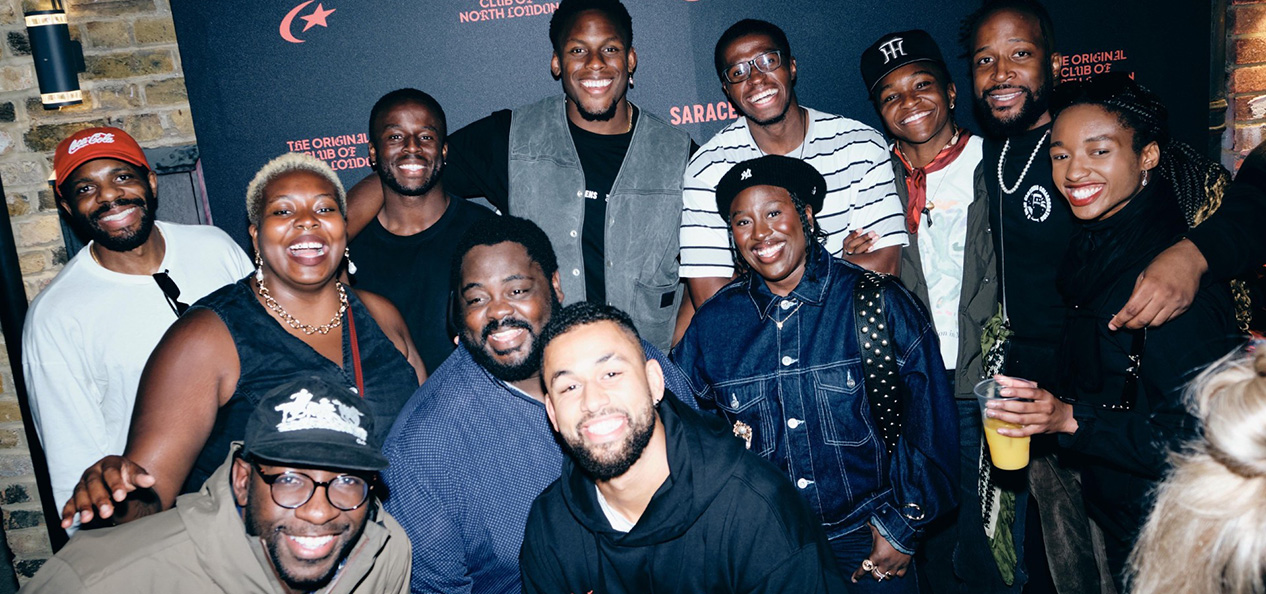 A group of people smile while on an indoors event.