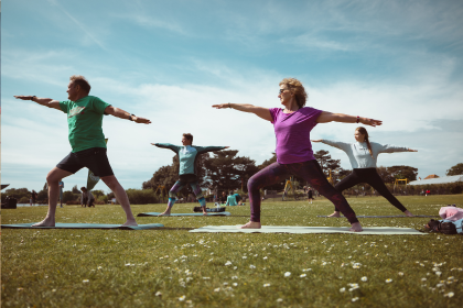 People doing yoga in a park