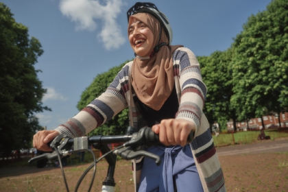 A woman rides a bike in the park