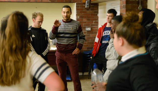 Coach talking to young people in rounds