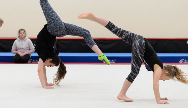 Two girls doing gymnastics in sports hall