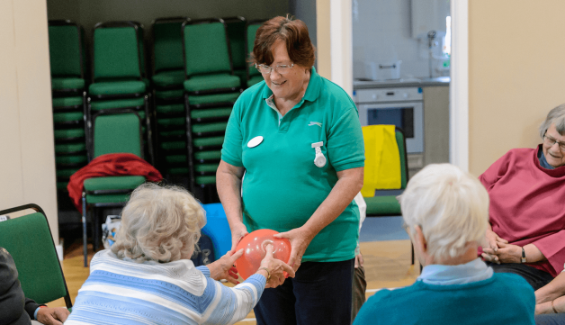 Volunteering group passing balloon