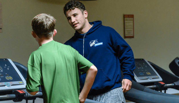 Volunteering gym trainer talking to jogger
