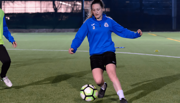 Woman dribbling during football game outdoors