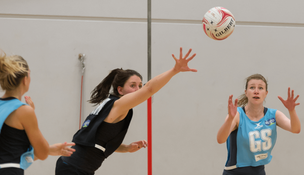 Women playing netball in sports hall