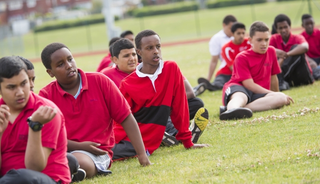 Athletics boys sitting down on the grass