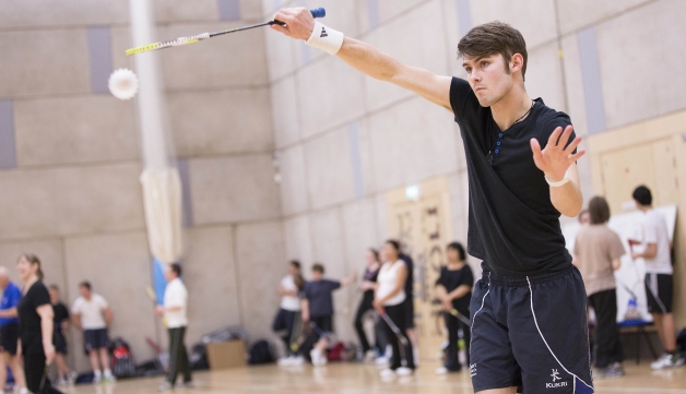 Badminton front view of man hitting shuttle