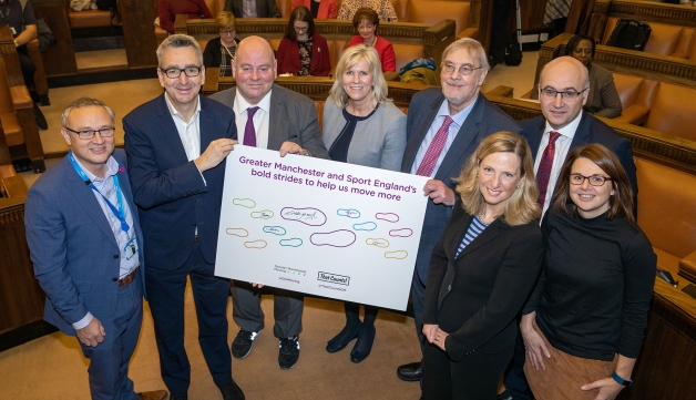 group of people holding a sign which reads Greater Manchester and sport England's bold strides to help us move more