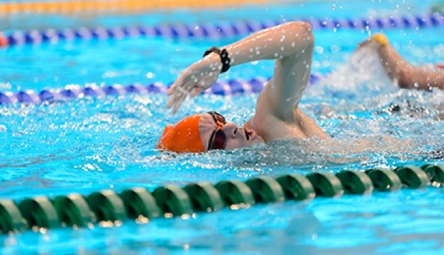A man swimming at the London Aquatics Centre.