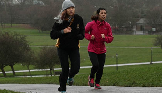 Two joggers run through a park