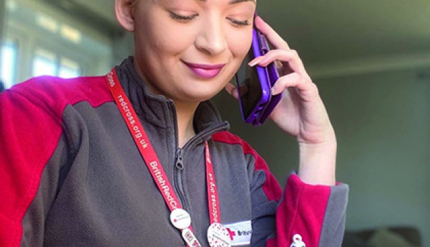 A British Red Cross volunteer on the phone.