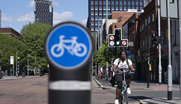 A woman cycles in a cycle lane in Manchester.