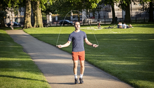 A man skipping on a path in a park