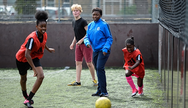 A coach watches on during a football session on a five-a-side pitch
