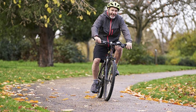 A man rides a bike in a park