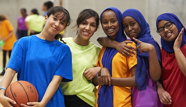 A groups of girls playing netball, pose for a team photo