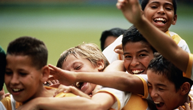 A group of young boys celebrate at a football match. Credit: Juan Silva/The Image Bank via Getty Images.