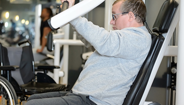 A man uses a chest press machine in the gym