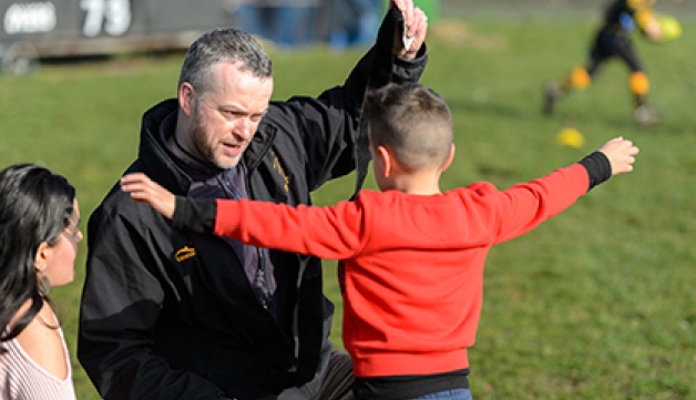 A coach puts tag rugby straps on a child
