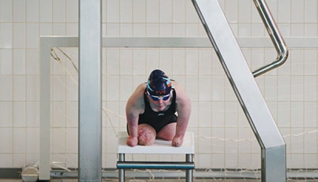 Para swimmer Ellie Challis prepares to dive into a swimming pool
