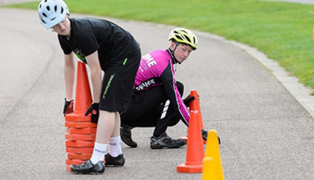 Two young cyclists lay out cones for a skills drill.