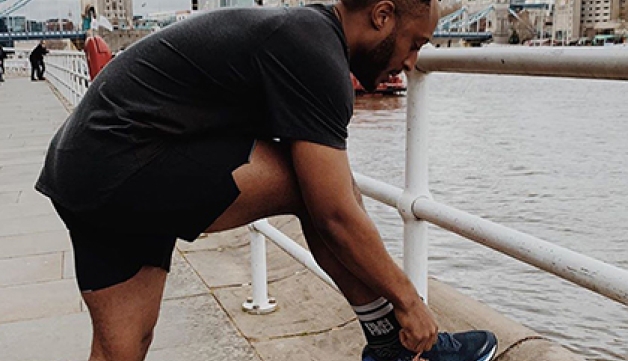 A man ties his shoe lace ahead of a run