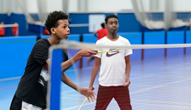 Two boys play badminton in a school PE lesson