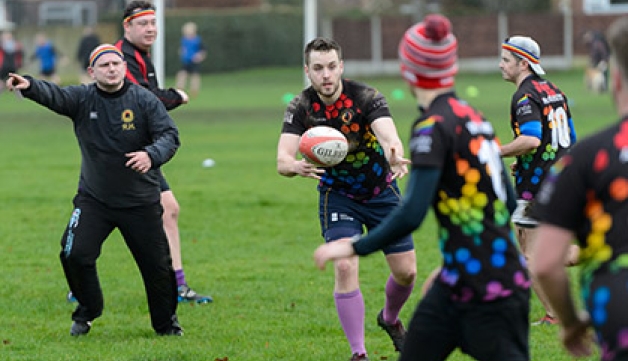 A man passes a rugby ball to a teammate during a training session