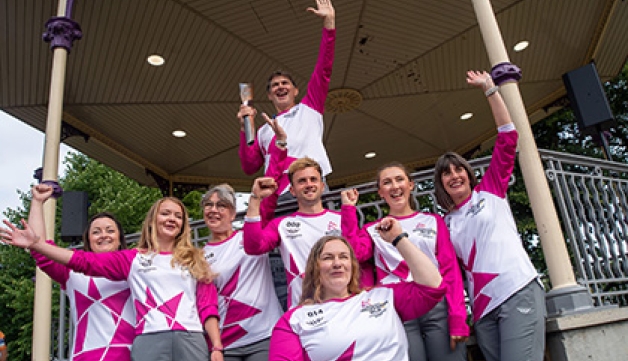 A group of Queen's Jubilee Baton Relay runners pose for a photo with the baton.