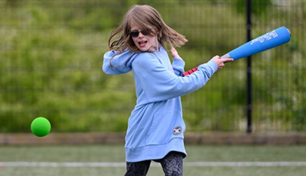A girl playing rounders