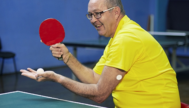 We Are Undefeatable case study Simon, plays table tennis in his wheelchair, with a blood glucose monitor patch on his arm
