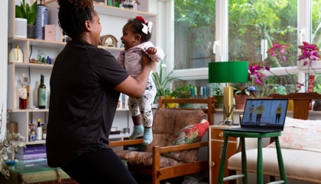 A mum does an exercise class in her living room, with her baby