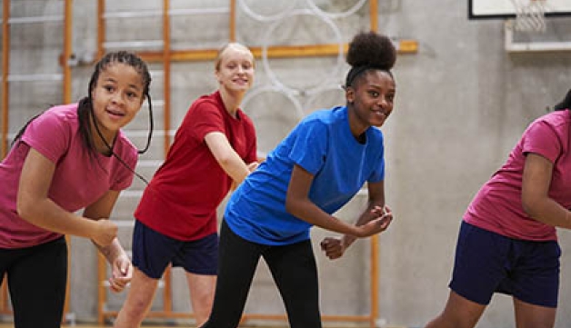 A group of teenage girls take part in an exercise class