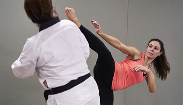 A woman performs a taekwondo head kick