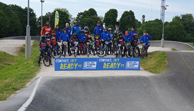 Children and coches from Peckham BMX Club pose for a picture on the track
