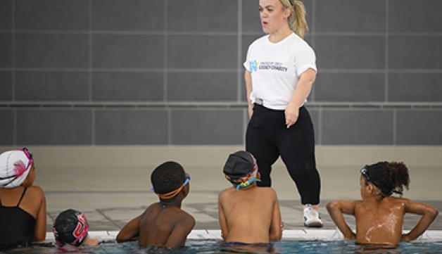 Ellie Simmonds stands at the side of the pool, coaching a group of children from the local community, at the opening of the Sandwell Aquatics Centre.