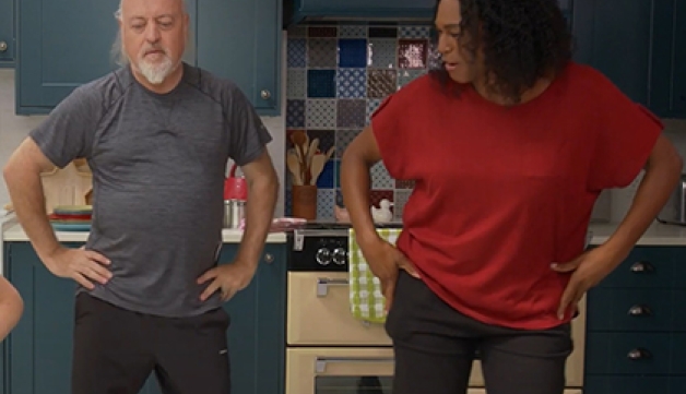 Bill Bailey and an instructor perform hip circles in a kitchen