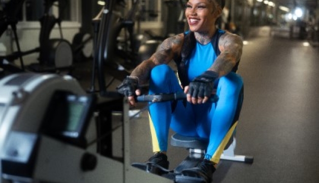 A smiling woman on a rowing machine in a gym