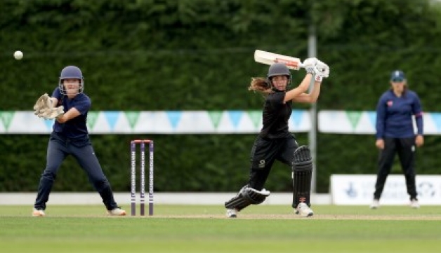 A batter hits a shot while the wicketkeeper looks on, during a girls' cricket game at the 2021 School Games National Finals at Loughborough University.