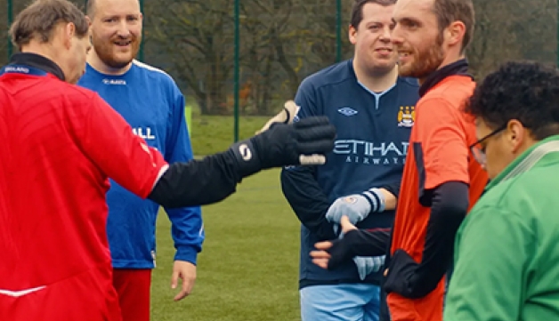 Members of Blokes United talk to each other on the pitch