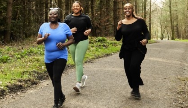 Three women stride through a forest