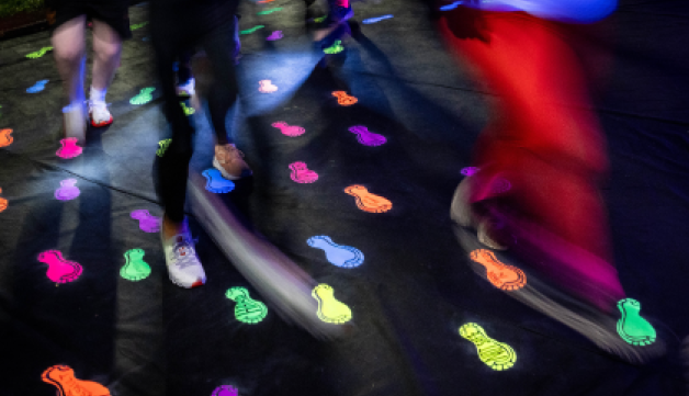 Runners run over glow-in-the-dark footprint stickers at night