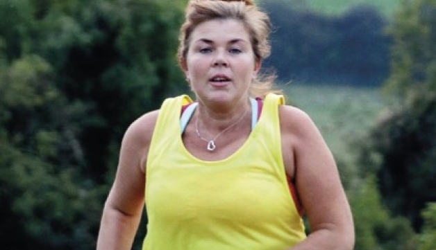 A woman jogs on a country track.