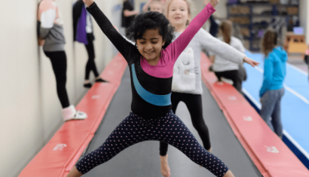 Young girls jumping on long trampoline.