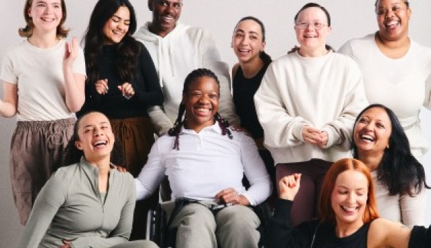 A group of women with a variety of characteristics smile for a posed shot.